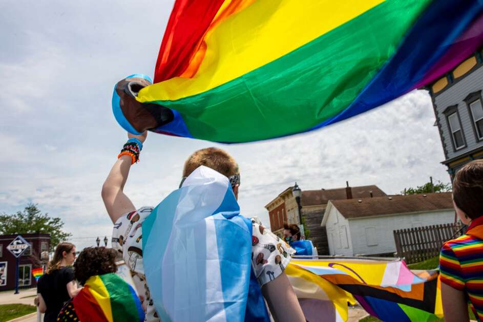 A parade participant waves a pride flag during the Cedar Rapids Pride Parade in Cedar Rapids, Iowa on Saturday, June 4, 2022. (Nick Rohlman/The Gazette)