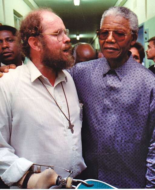 The Rev. Michael Lapsley appears in an undated photo with African National Congress leader and former South African president Nelson Mandela after Mandela’s release from prison in 1990. Lapsley’s work in healing trauma through storytelling started after the anti-apartheid activist survived a letter bomb sent to him in 1990 by the pro-apartheid South African regime. Lapsley lost both hands and eyesight in one eye from the attack. (Institute for Healing of Memories)