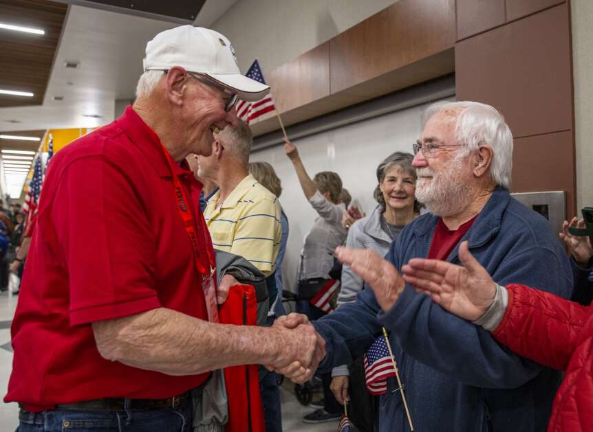 Jim Carver of Alburnett shakes veteran Leland Osmundson’s hand as he is welcomed back from the Honor Flight at the Eastern Iowa Airport in Cedar Rapids, Iowa on Tuesday, April 25, 2023. (Savannah Blake/The Gazette)