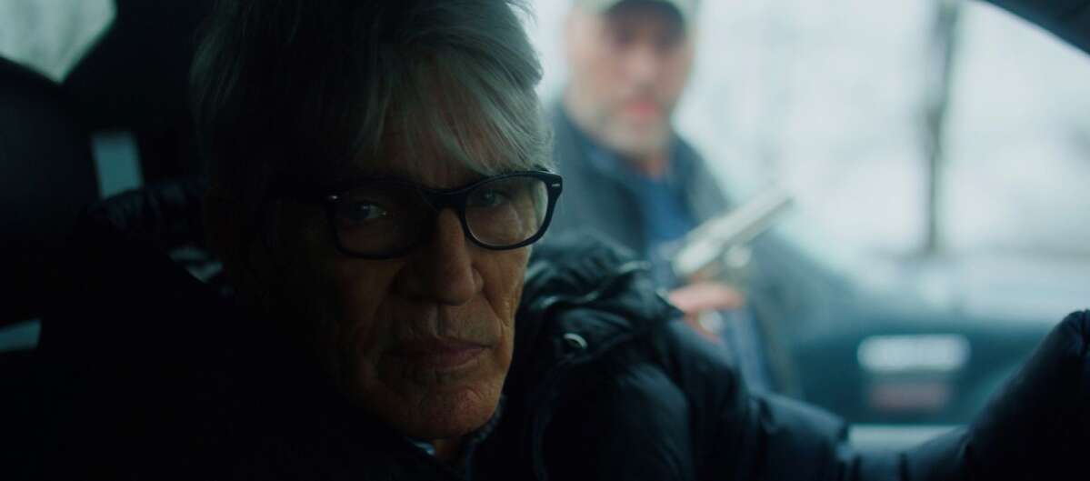 KMRY radio host Ricky Bartlett is seen approaching another character in a screenshot of his upcoming role in “Intent Unknown,” an independent Iowa-filmed thriller movie. Actor Eric Roberts, Julia Roberts’ brother, plays Dr. Drew Campbell in the foreground — the movie’s antagonist. (TNG Films LLC)