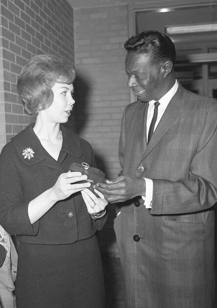 Mrs. James A. Johnson of Cedar Rapids presents singer Nat King Cole with honorary membership in the Cedar Rapids Twin Club on Nov. 19, 1963, when the entertainer appeared at the Iowa Theater. Cole and his wife, singer Maria Hawkins, had twin daughters in 1961. (Gazette archives)