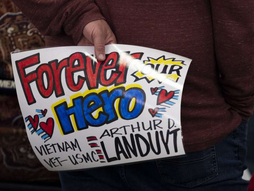 A man holds a sign for a returning veteran from the Honor Flight at the Eastern Iowa Airport in Cedar Rapids, Iowa on Tuesday, April 25, 2023. (Savannah Blake/The Gazette)
