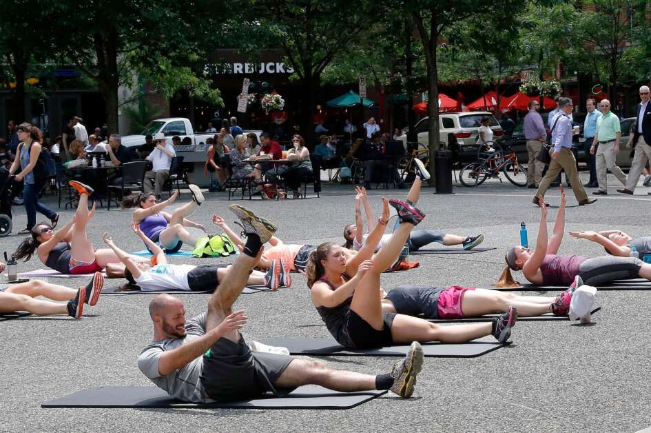 An exercise group from a YMCA in downtown Pittsburgh does what they call a high intensity interval training workout as part of their "Move it Mondays" program every week through July at Market Square in downtown Pittsburgh on Monday, June 6, 2016. The YMCA invites anyone to participate and does not require a membership. (AP Photo/Keith Srakocic)