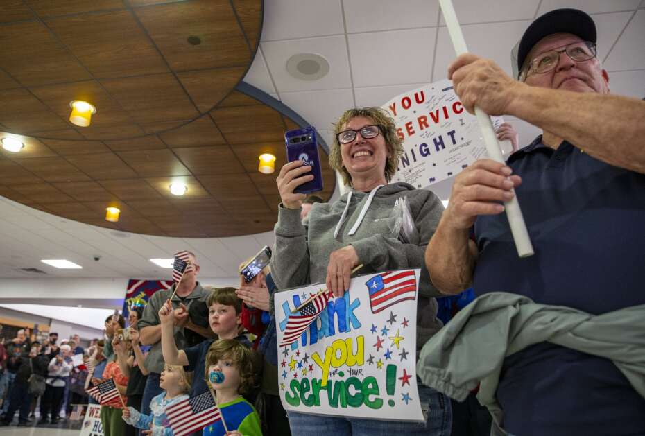 People celebrate the arrival of veterans after their return on the Honor Flight at the Eastern Iowa Airport in Cedar Rapids, Iowa on Tuesday, April 25, 2023. (Savannah Blake/The Gazette)