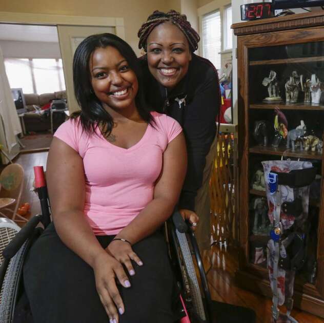 Denisha Davis, then 19, with her mother, Denia, as they talk Dec. 19, 2014, about the March 2014 shooting that left Denisha paralyzed from the waist down and her continuing rehabilitation in her northeast Cedar Rapids home. (Jim Slosiarek/The Gazette)