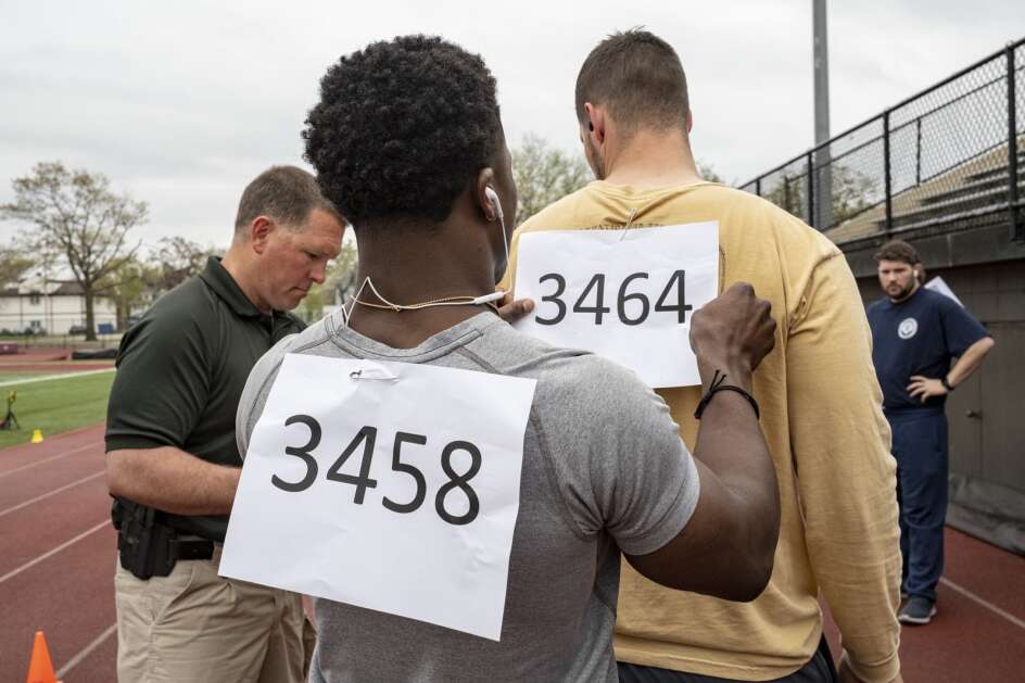 Jordan Myles, 22, of Marion, pins a number onto another applicant Saturday during testing for law enforcement applicants hosted by the Linn County Sheriff's Office at Coe College in Cedar Rapids. (Nick Rohlman/The Gazette)