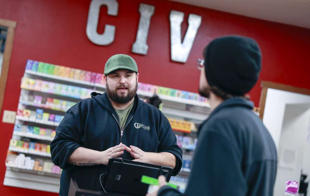 Alex Biggart (right). manager at Central Iowa Vapors in northeast Cedar Rapids talks Friday to customer Bradley Betters. A bill working its way through the Iowa Legislature and supported by the tobacco industry would ban retailers like Central Iowa Vapors from selling vape products not listed on a state-approved registry. (Jim Slosiarek/The Gazette)