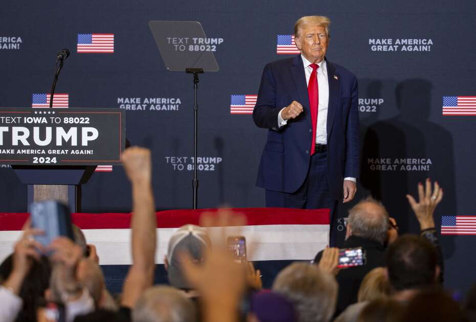 Former President Donald Trump raises his fist Saturday to the crowd as attendees give him a standing ovation after he came on stage at the DoubleTree by Hilton Cedar Rapids Convention Complex in downtown Cedar Rapids. (Savannah Blake/The Gazette)