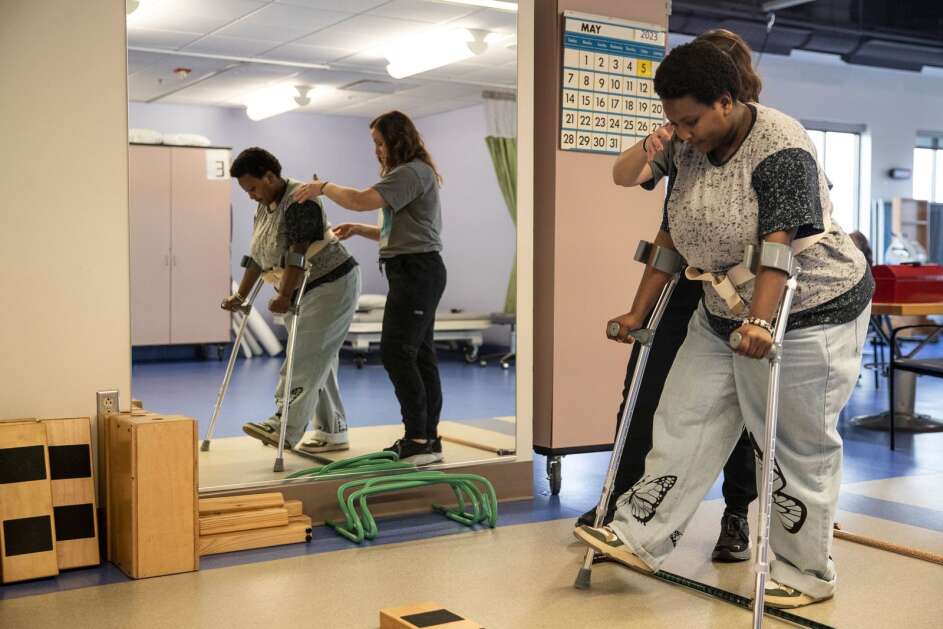 Nakiza Nyankundwa, a senior at Jefferson High School, works May 5 with therapist Jen Janatscheck to complete her exercises at UnityPoint Health-St. Luke’s Hospital in Cedar Rapids as she learns to walk with a prosthetic leg. “I’m thankful I’m alive,” Nyankundwa said in an interview. “I would like to encourage other kids that have disabilities to just be themselves and not worry about what other people think or say about them.” (Geoff Stellfox/The Gazette)