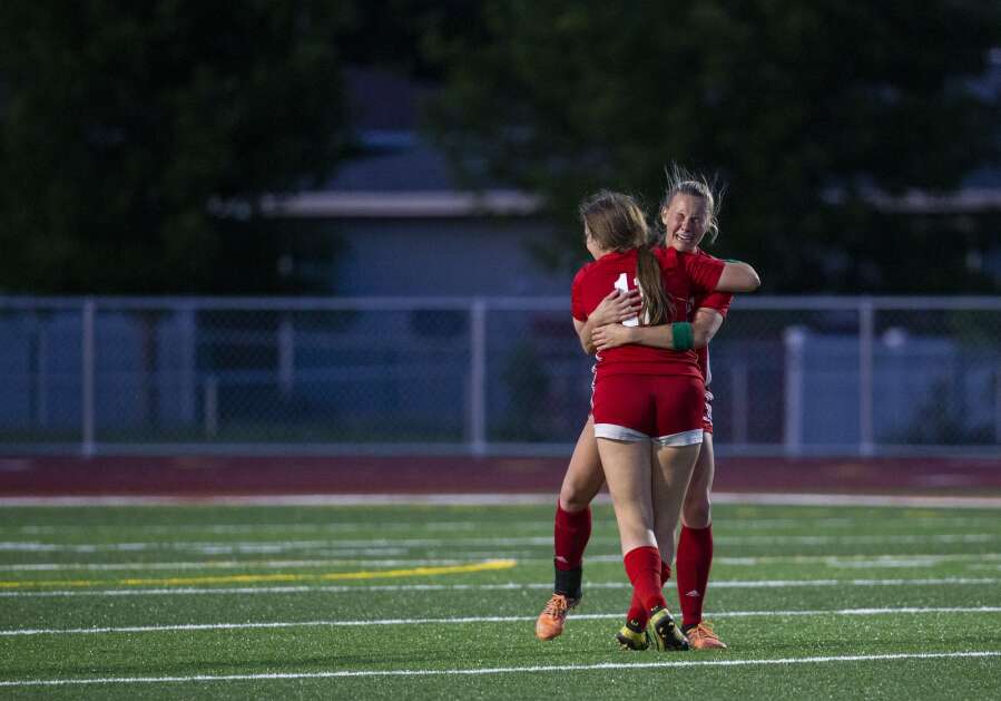 Marion defender Ellie Hatfield (26) becomes emotional as she hugs teammate Marion defender Amerie Hall (11) after the Wolves defeated the Lightning to advance to state at Marion High School in Marion, Iowa on Thursday, May 25, 2023. (Savannah Blake/The Gazette)