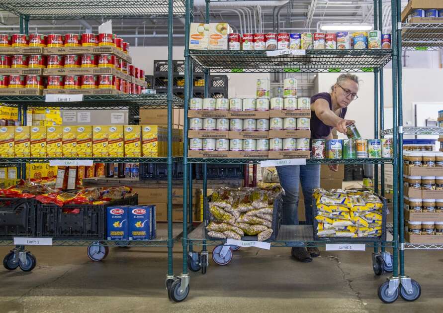 Volunteer Barbara Eckstein stocks shelves May 16 at the CommUnity Food Bank in Iowa City. She has been volunteering at the food bank for six months. CommUnity has been serving about 1,100 households each week. (Savannah Blake/The Gazette)