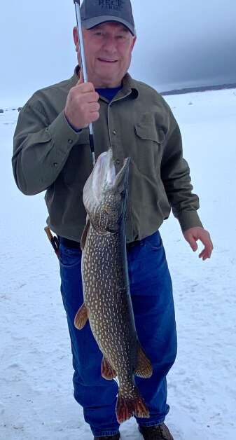 Doug Rick of Winthrop stands with a 39.5-inch northern pike he caught Jan. 25 through the ice above Lake of the Woods.  (Orlan Love/Reporter)