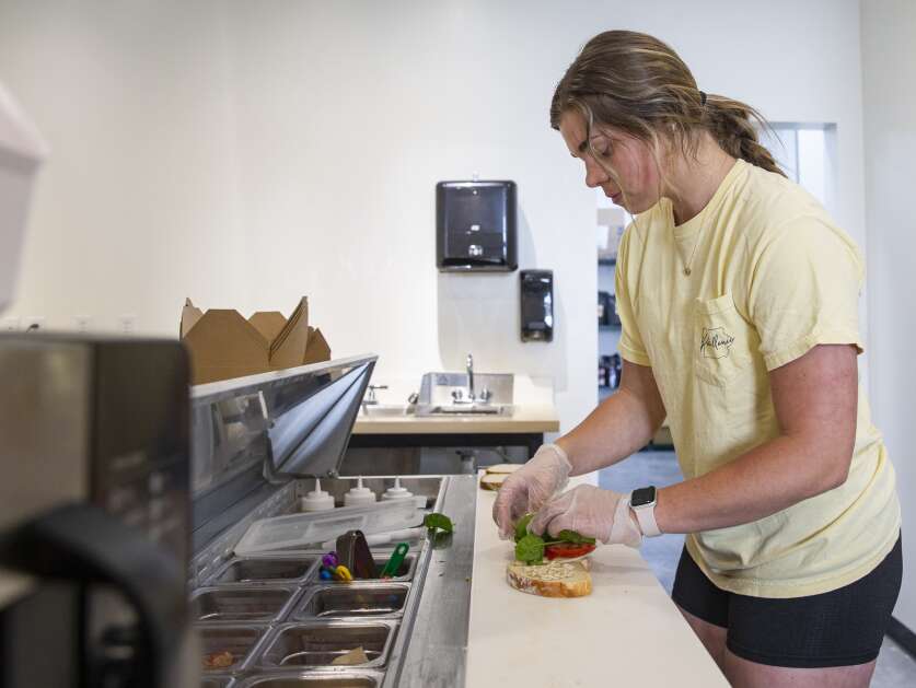 Employee Payton Wubben prepares the garden sandwich at the Coffee Emporium in Tiffin, Iowa, on Thursday, May 18, 2023. (Savannah Blake/The Gazette)