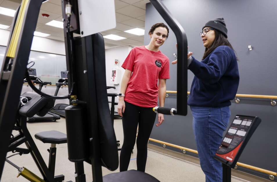Project coordinator Abigail Burkhart (left) plays the role of a research study participant Thursday allowing fellow project coordinator Abigail Molina to practice her research instructions and procedure during a familiarization session for a research study at Iowa State University’s Wellbeing and Exercise Laboratory in Ames. (Jim Slosiarek/The Gazette)