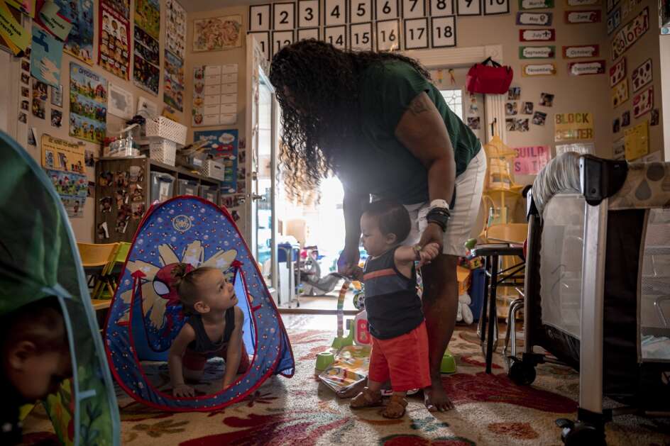 Denia Davis plays Friday with Gabriel Davis, age 3 (center, in the tent) and his younger brother, Josiah, at home in northeast Cedar Rapids. Denia Davis, who works as an in-home child care provider, adopted her cousin's son (Gabriel) and is fostering his brother (Josiah). (Nick Rohlman/The Gazette)