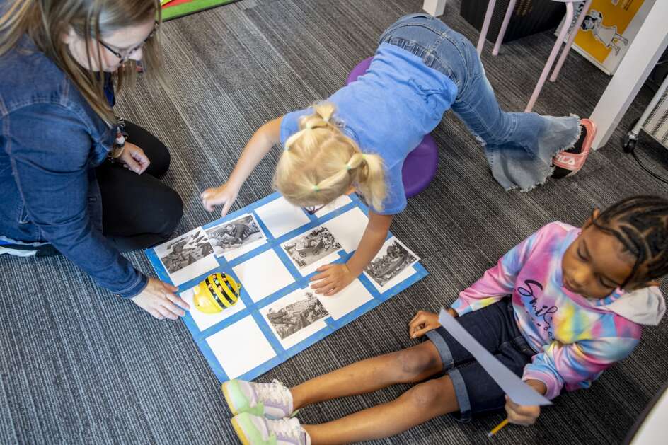 Second grade teacher Melissa Cahalan works with second graders Da’Neyah Boothe (right) and Stella Meyers (center) on an exercise with BeeBots, bee robots used as a teaching tool in computer science instruction, at Longfellow Elementary in Marion, Iowa on Thursday, September 14, 2023. The exercise assigned one student as a driver and one as a navigator to work in a team to program and debug the BeeBot’s route. (Nick Rohlman/The Gazette)**cq**