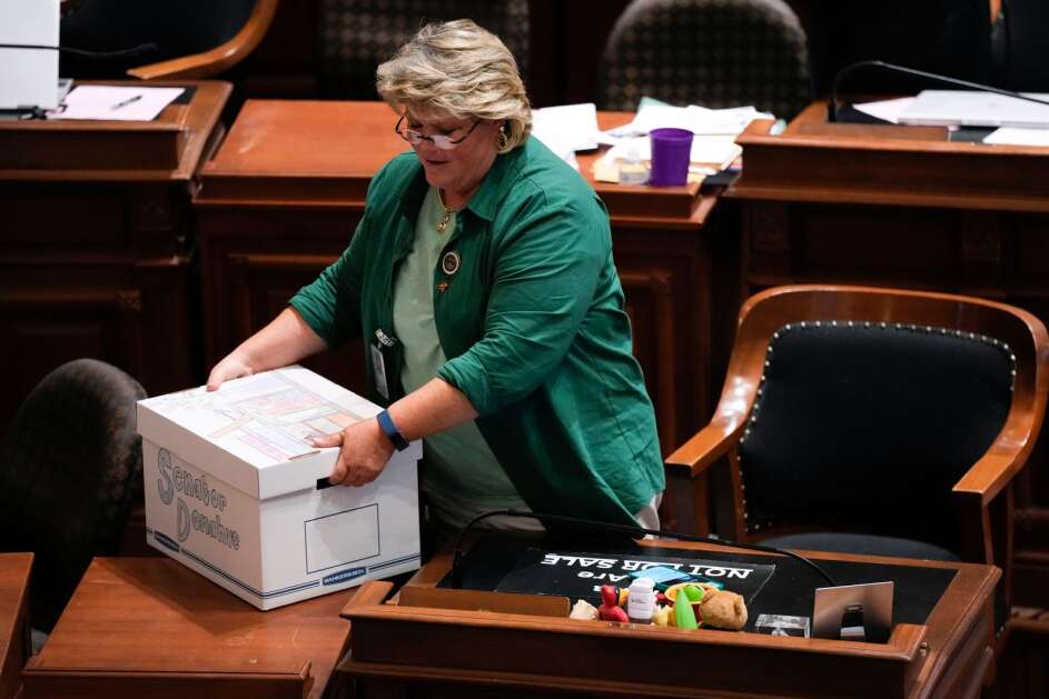 Sen. Molly Donahue, D-Cedar Rapids, packs up her desk Thursday in the Iowa Senate chamber at the Capitol in Des Moines. (Associated Press) 