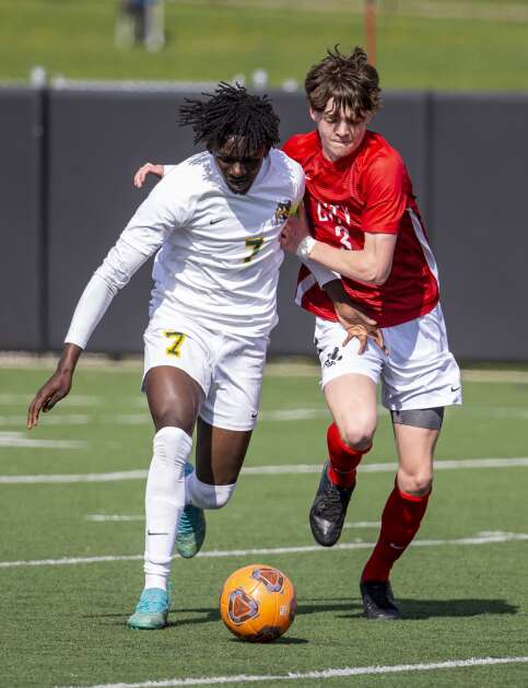 City High Little Hawks forward Jackson Lindsey (3) guards Kennedy Cougars midfielder Lwings Kabula (7) as he drives the ball down the field in the first half of the game at Iowa City High in Iowa City, Iowa on Tuesday, April 25, 2023. (Savannah Blake/The Gazette)