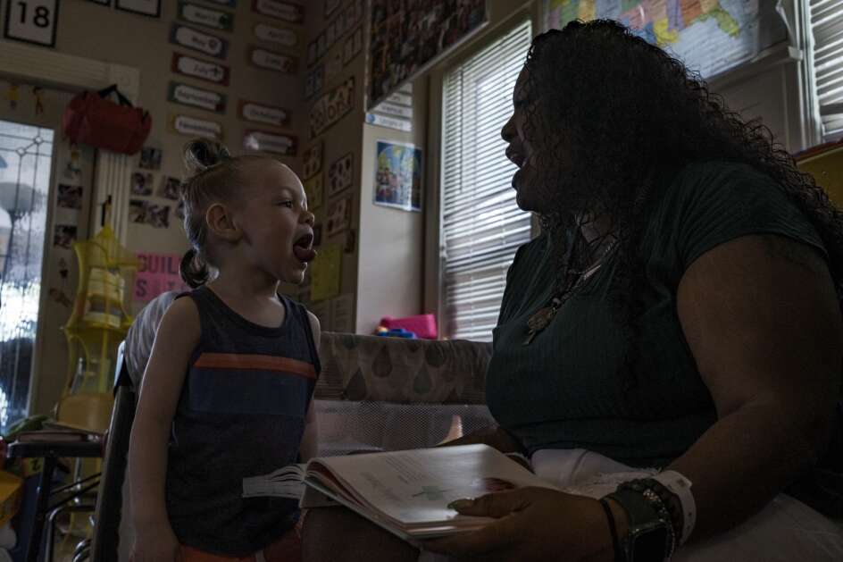 Denia Davis reads a picture book Friday with her son, Gabriel, at  home in Cedar Rapids. Denia Davis began fostering Gabriel when he was an infant and now has adopted him. She fosters his younger brother, Josiah. (Nick Rohlman/The Gazette)