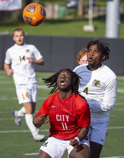 City High Little Hawks forward Barick Makabi (11) and Kennedy Cougars defender Amisi Lubosha (4) both look up at the ball as they compete for possession in the second half of the game at Iowa City High in Iowa City, Iowa on Tuesday, April 25, 2023. (Savannah Blake/The Gazette)