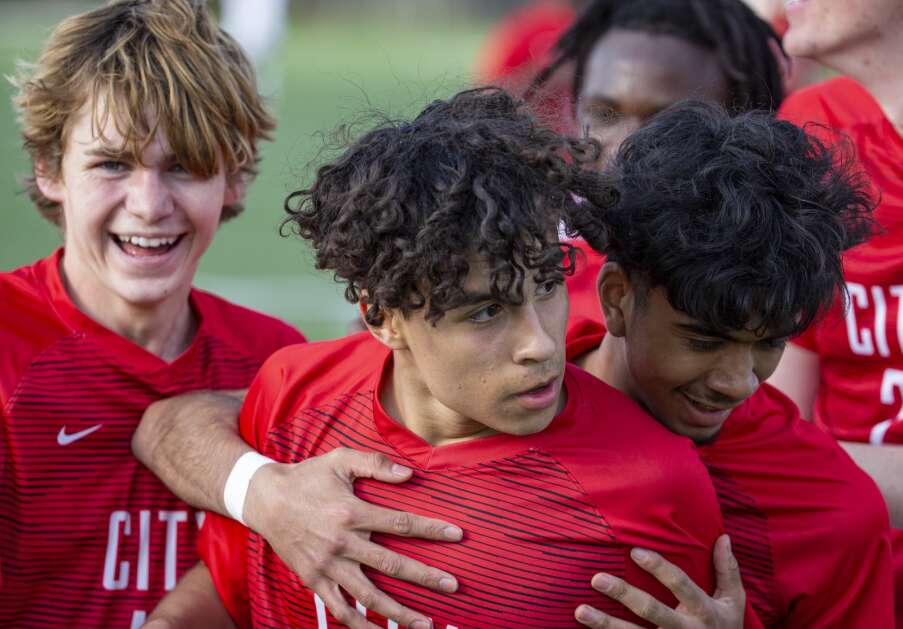 Teammates surround City High Little Hawks midfielder Josh Borger-Germann (18) in celebration after he scored the first goal of the against against Kennedy in the second half of the game at Iowa City High in Iowa City, Iowa on Tuesday, April 25, 2023. (Savannah Blake/The Gazette)