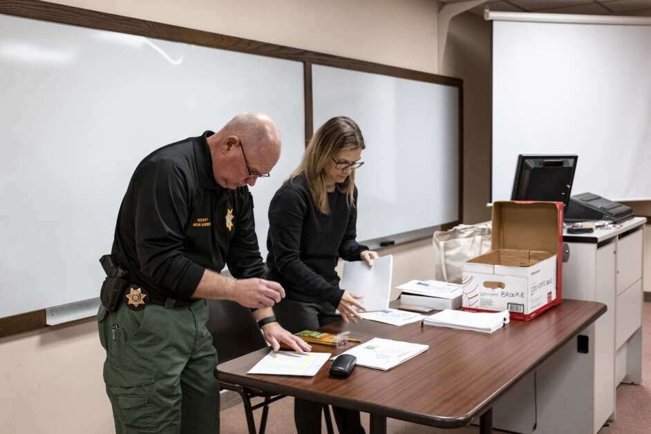 Linn County Sheriff Brian Gardner and administrative coordinator Brooke Henning prepare written exams Saturday during testing for law enforcement applicants hosted by the Linn County Sheriff's Office at Coe College in Cedar Rapids. (Nick Rohlman/The Gazette)