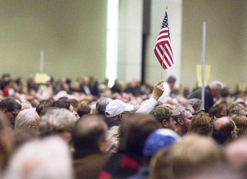 A caucus-goer holds up an American flag Feb. 1, 2016, at the Republican caucus at the DoubleTree Hotel and Convention Center in downtown Cedar Rapids. (The Gazette)