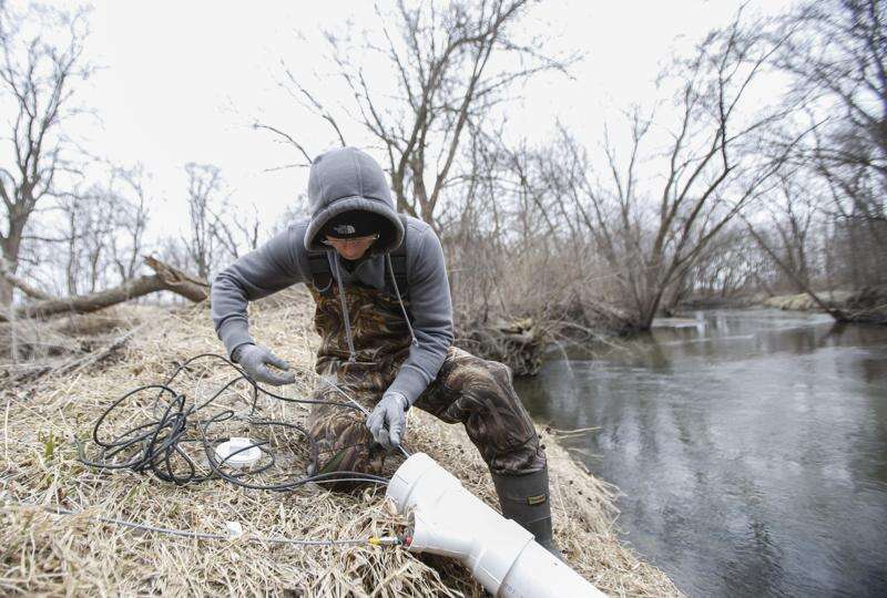 Jason McCurdy, a researcher and field technician at the IIHR Hydroscience and Engineering center at the University of Iowa's College of Engineering, installs a water quality sensor used for testing nitrate levels at Miller Creek, west of Gilbertville on Thursday, March 23, 2017. The program has installed the sensors across the state in order to establish a baseline report of various water quality indicators. (Rebecca F. Miller/The Gazette)