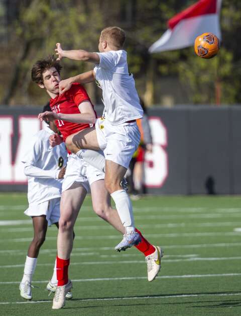 Kennedy Cougars defender Trevor Shanle (14) hits City High Little Hawks forward Jude Geerdes (21) as they both try to head the ball in the second half of the game at Iowa City High in Iowa City, Iowa on Tuesday, April 25, 2023. (Savannah Blake/The Gazette)