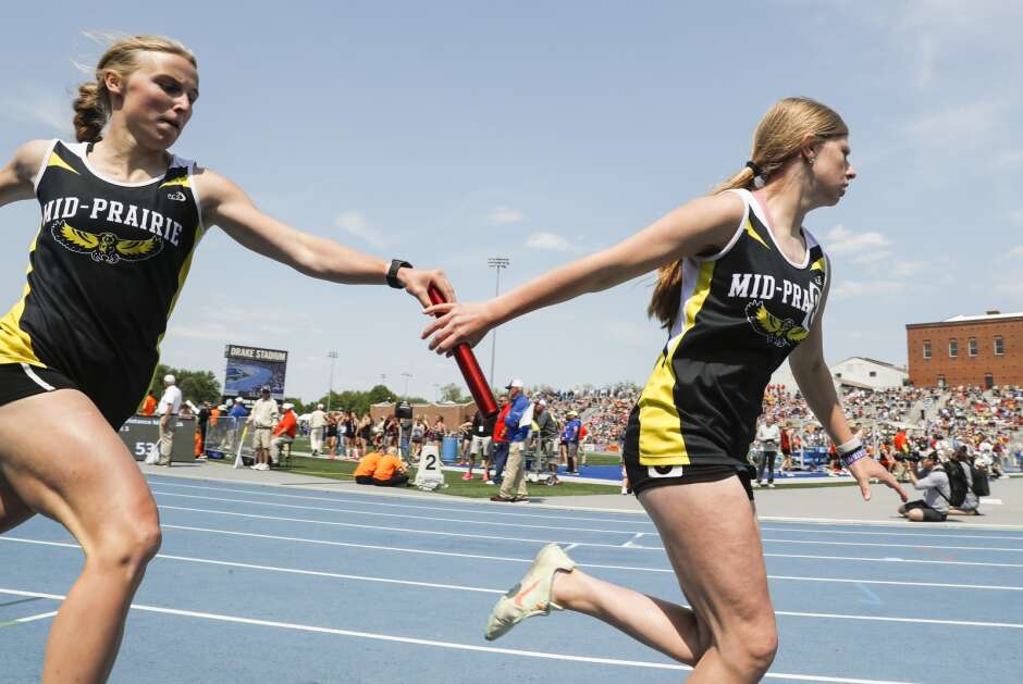 Mid-Prairie's Amara Jones (left) hands off to Jovi Evans during the Class 2A girls’ state track and field distance medley relay Friday at Drake Stadium in Des Moines. (Jim Slosiarek/The Gazette)