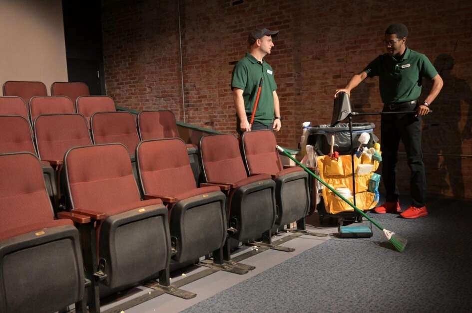 "The Flick," onstage Nov. 25 to Dec. 11, 2022, at Riverside Theatre in Iowa City, takes viewers behind the scenes at a rundown art house cinema. In this scene, Sam (Elijah Jones, left) and Avery (Ren Price) tackle the everyday, mundane chore of sweeping up pop and popcorn between shows. The play pays tribute to the power of movies and paints a heartbreaking portrait of three characters and their working lives. (Rob Merritt)