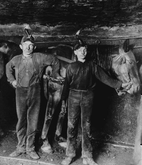 Two young boys in their early teens work in a West Virginia coal mine in this 1908 photo.  In the early 1900's, workers virtually had no rights in the workplace.  Today, many new laws are in place to protect workers lives and dignity while working, including the child labor laws of 1916.  (AP Photo)