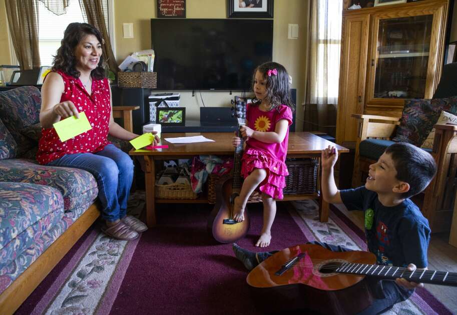 Four-year-old Astrid Rustebakke watches as her mother, Gabriella Rustebakke, practices spelling April 13 with her son, Paul Rustebakke, 7, at their home in Cedar Rapids. Rustebakke went from working as a supervising teacher at the Marion home schooling assistance program to home schooling her own children. (Savannah Blake/The Gazette)