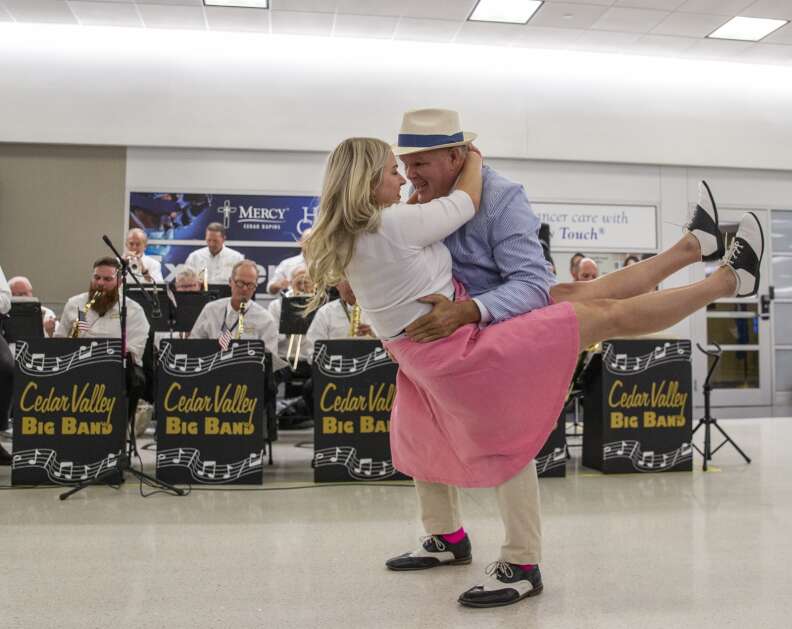 Five Seasons Swing members Sonia Brietzke of Marion dances with Thomas Roeder of Welton while waiting for the arrival of the Honor Flight at the Eastern Iowa Airport in Cedar Rapids, Iowa on Tuesday, April 25, 2023. (Savannah Blake/The Gazette)