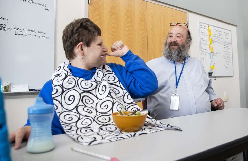 Teacher Thomas Braverman (right) talks with student Jason Snow, 21, while they eat the lunch they prepared Friday at the Clear Creek Amana Community School District in Tiffin. Braverman, who’s worked with special education students in Eastern Iowa for 35 years, is a finalist for this year’s Teacher of the Year award from the Iowa Department of Education.  (Savannah Blake/The Gazette)