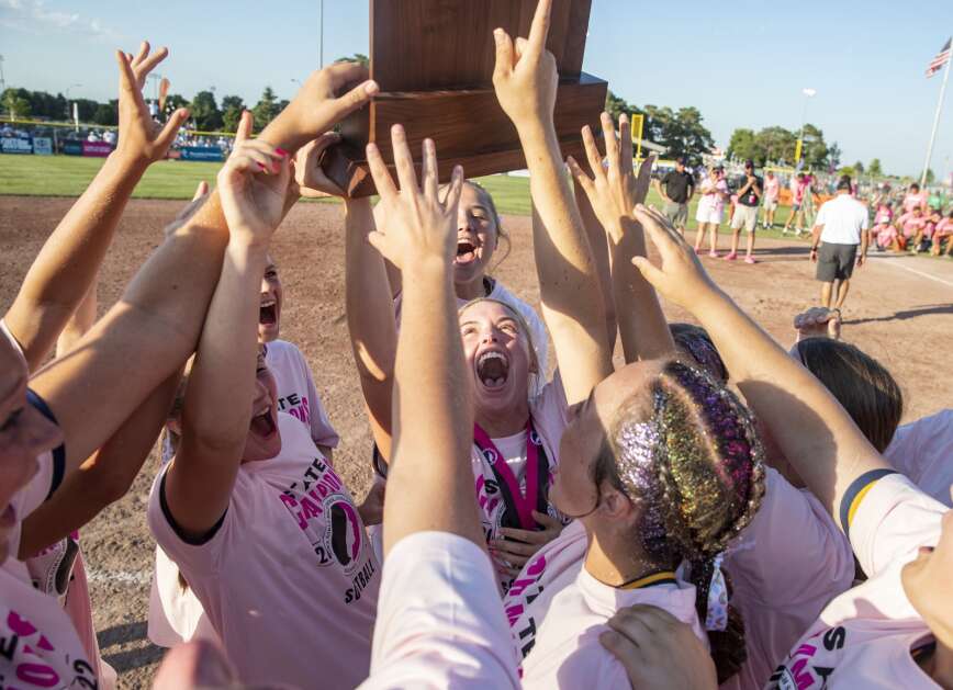 Iowa City Regina players hold up the state-championship trophy after defeating Wilton, 6-4, during the Class 2A state final last year at Fort Dodge. (Savannah Blake/The Gazette)