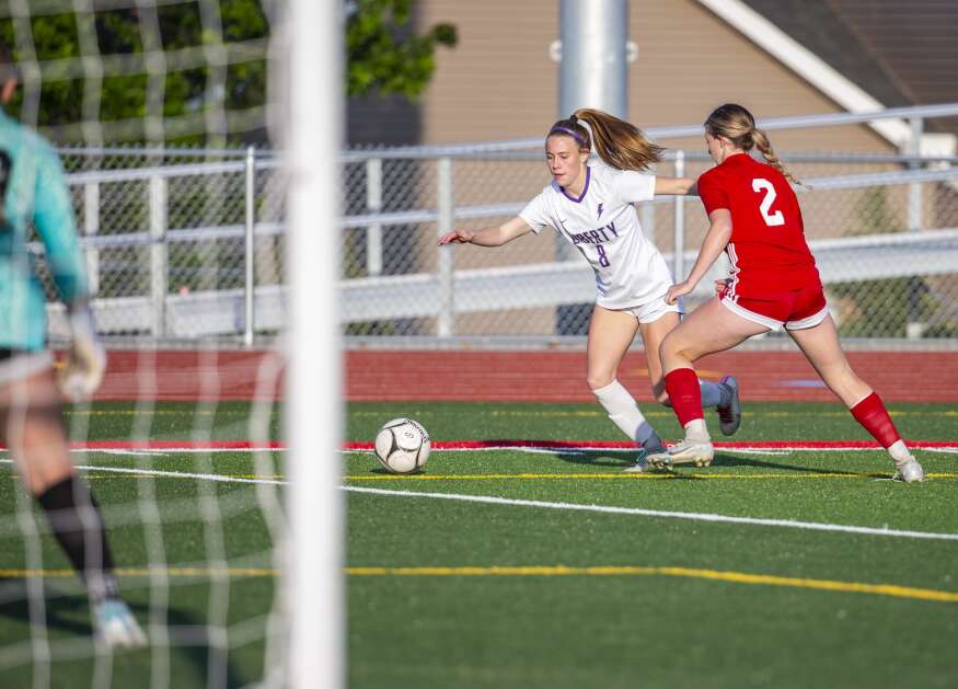 Marion defender Katelyn Allison (2) guards Iowa City Liberty midfielder Callie Stanley (8) as she dribbles the ball towards the Marion goal in the first half of the game at Marion High School in Marion, Iowa on Thursday, May 25, 2023. (Savannah Blake/The Gazette)