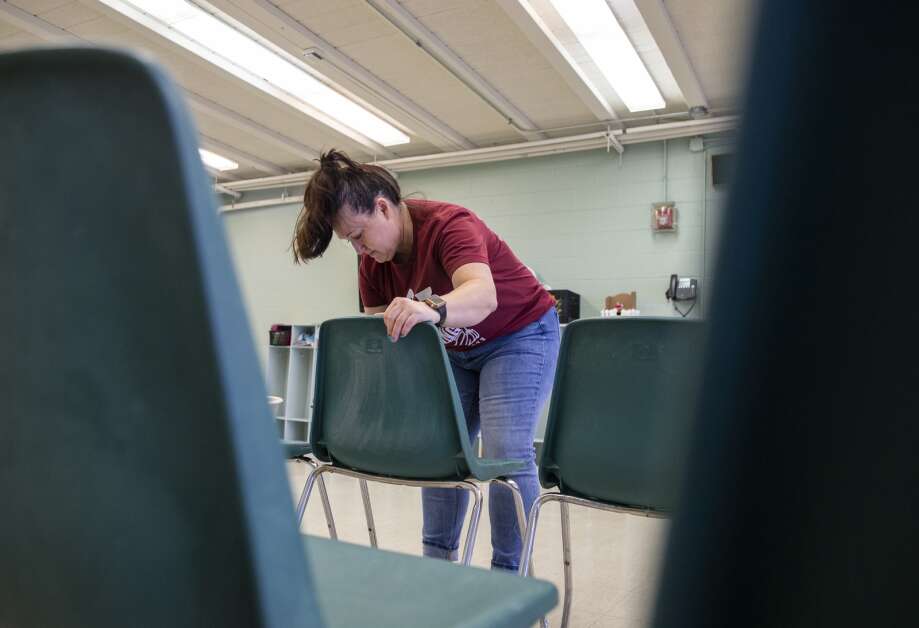 CRST employee Jody Glazier wipes down classroom chairs while volunteering for Day of Caring at Jane Boyd Community House in Cedar Rapids, Iowa on Thursday, May 11, 2023. (Savannah Blake/The Gazette)