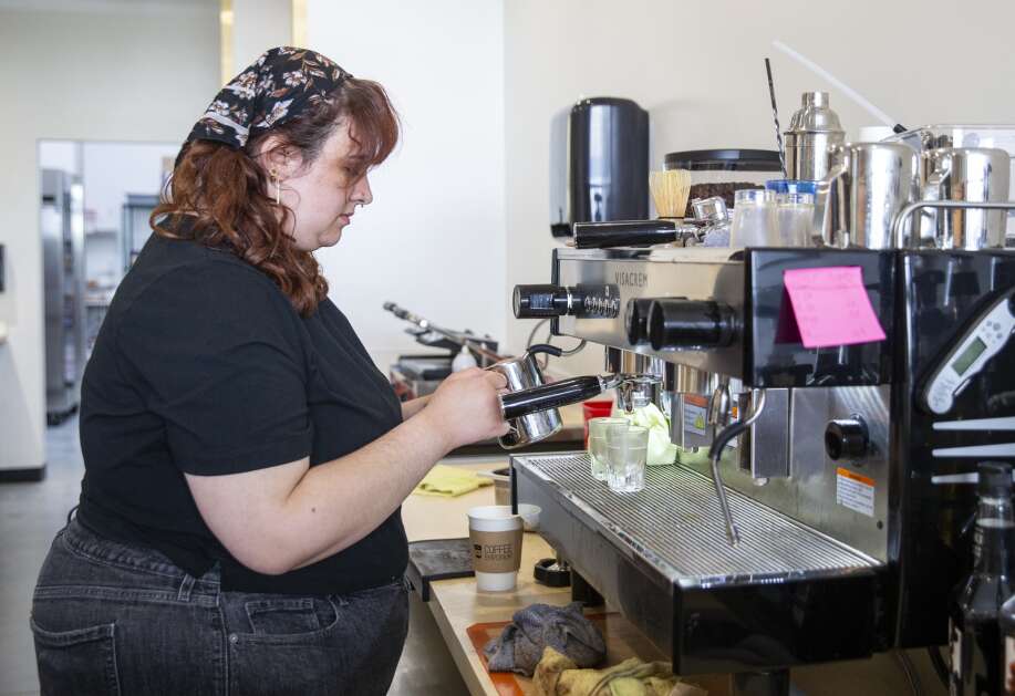 Employee Bethany Kasperek steams milk for a latte while working at the Coffee Emporium in Tiffin, Iowa, on Thursday, May 18, 2023. (Savannah Blake/The Gazette)