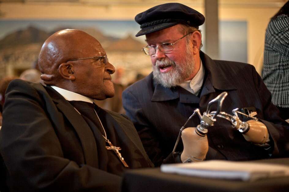 The Rev. Michael Lapsley, an Anglican priest of the Society of the Sacred Mission order, talks to the Rev. Desmond Tutu, a renowned South African archbishop and theologian. Lapsley’s global work in healing trauma through storytelling started after the anti-apartheid activist survived a letter bomb sent to him in 1990 by the pro-apartheid South African regime. Lapsley lost both hands and eyesight in one eye from the attack. (Institute for Healing of Memories)