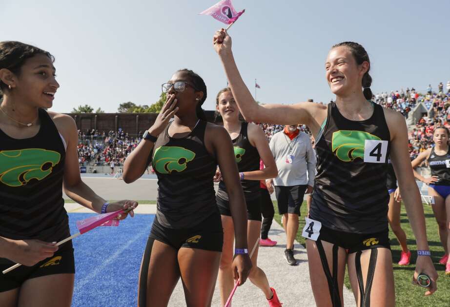 Cedar Rapids Kennedy anchor Sidney Swartzendruber (right) waves the championship flag as she celebrates winning the Class 4A girls’ state track and field sprint medley relay with teammates from left: Morgan Hospodarsky, Quren Hullon and Addison Swartzendruber at Drake Stadium in Des Moines on Saturday. (Jim Slosiarek/The Gazette)