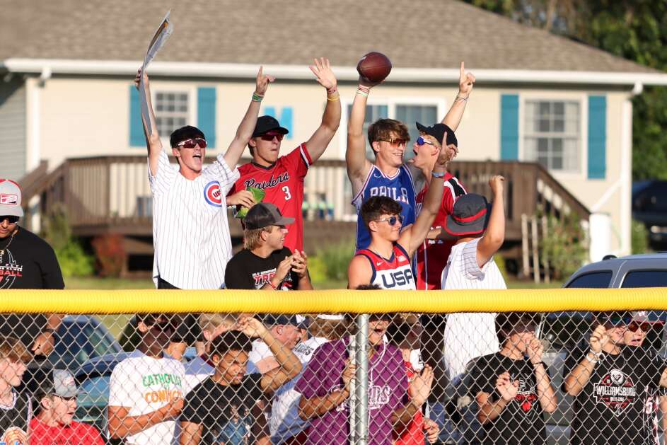 Williamsburg High School students cheer from outside the left-field fence after home run last season. (The Gazette)