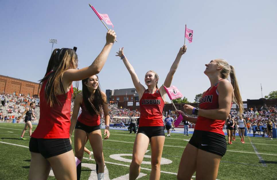 Lisbon's Brynn Epperly (second from right) raises her arms in victory as she celebrates winning the Class 1A girls’ state track and field 400-meter relay with teammates Ava Czarnecki (second from left), Peyton Robinson (right) and Addy Happel (left) Saturday at Drake Stadium in Des Moines. (Jim Slosiarek/The Gazette)