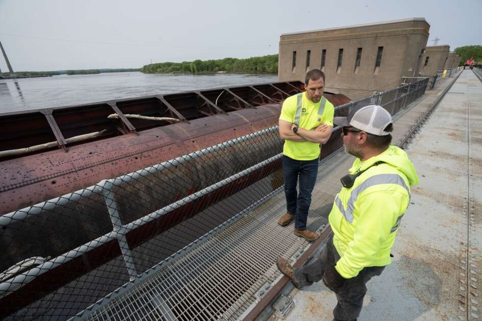 U.S. Army Corps of Engineers employees Aaron Brown and Troy Frank stand near one of the roller gates used to regulate the flow of water May 17 at Lock and Dam #8 in Genoa, Wis. The locks allow the boats to gradually adjust to changing river levels. Most towboats can push 15 barges at a time on the river. When those barges reach a 600-foot long lock, they don’t fit. Instead, they have to be split up, which takes more than twice as long.It was constructed and was put into operation by April 1937. (Mark Hoffman/Milwaukee Journal Sentinel)