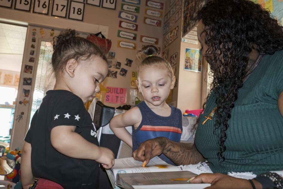 Denia Davis reads a picture book with her son Gabriel (center) and Legend Johnson, age 2, at home in northeast Cedar Rapids. Dais is an in-home child care provider to eight children. “My reward of being a day care provider is seeing them succeed out in the real world, seeing them become doctors and car mechanics,” she said in an interview. “Some of the kids come back and say, ‘If it wasn’t for you I wouldn’t be where I am today’.”  (Nick Rohlman/The Gazette)