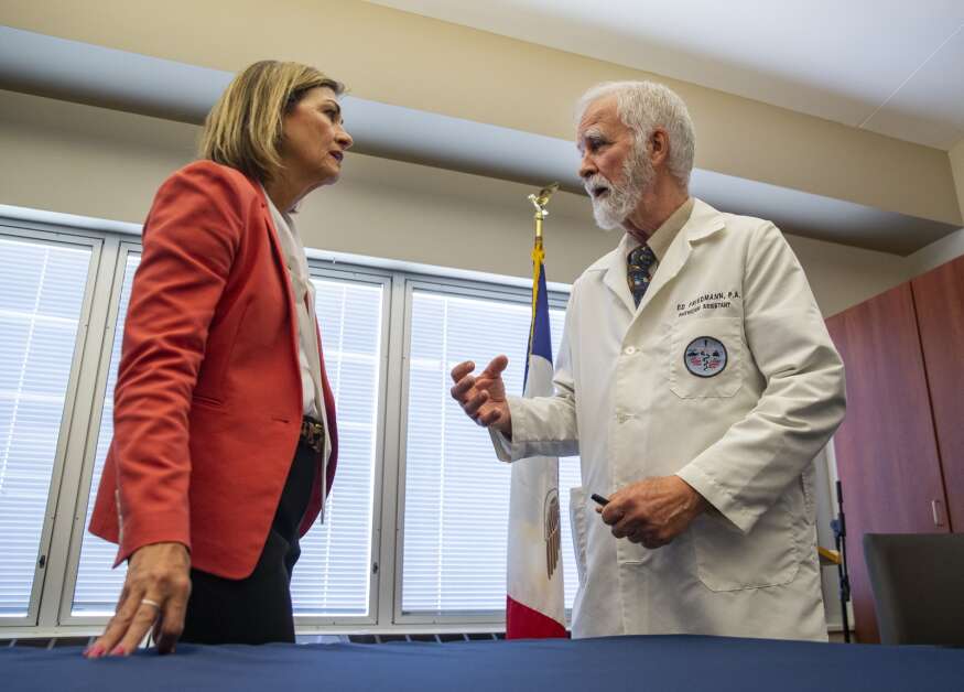 Physician Assistant Ed Friedmann talks Wednesday with Gov. Kim Reynolds after the signing of House File 424 at the Washington County Hospital and Clinics in Washington, Iowa. Reynolds talked with several PA’s who were in attendance about the impact of the new law. (Savannah Blake/The Gazette)