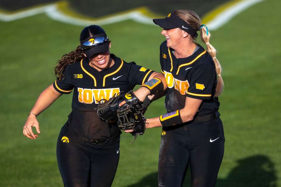 Iowa’s Tatianna Roman (9) is congratulated by teammate Tory Bennett (1) after making a diving catch during the Cy-Hawk softball game on Wednesday, April 26, 2023, at Pearl Field in Iowa City. (Geoff Stellfox/The Gazette)
