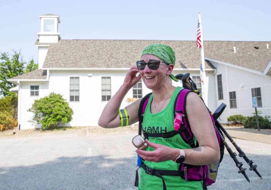 Karen Smith of Solon smiles Tuesday as she puts in her earbuds before heading out on her 4-mile practice walk from the Shueyville Community Center to her home. Smith will be walking across the state for mental health awareness June 9. She is raising money to support her walk, and money collected will be donated to four mental health organizations. (Savannah Blake/The Gazette)