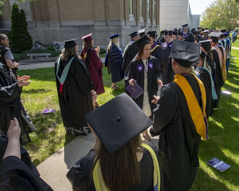 Faculty members congratulate students following a commencement ceremony at Iowa Wesleyan University in Mount Pleasant, Iowa on Saturday, May 6, 2023. The 2023 class will be the university’s last. The university, founded in 1842, will close permanently at the conclusion of the spring term after 181 years of operation. A statement from the university’s board of trustees cited “a combination of financial challenges – increased operating costs due to inflationary pressures, changing enrollment trends, a significant drop in philanthropic giving, and the rejection of a proposal for federal Covid funding by [Iowa Governor Kim Reynolds]” as the reasons for the closure. (Nick Rohlman/The Gazette)