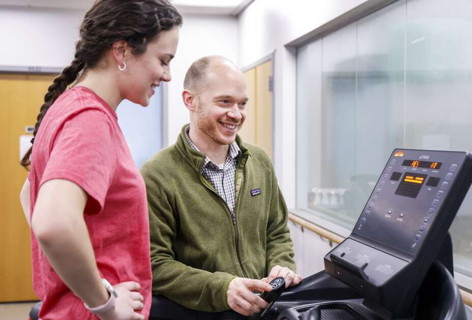 Iowa State University associate professor and lead researcher Jacob Meyer talks Thursday to project coordinator Abigail Burkhart as she warms up on a treadmill during a familiarization session for a research study at the Wellbeing and Exercise Laboratory in Ames. Meyer received over $5 million in grants to research whether, how and to what degree exercise and weight training can improved symptoms of depression. (Jim Slosiarek/The Gazette)